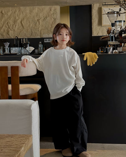 アイボリーの長袖カットソーとブラックのワイドパンツを合わせたキッズコーデ