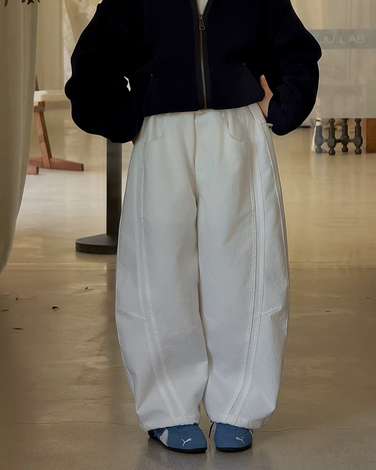 立体的な切り替えステッチが特徴のオフホワイトのバレルパンツ